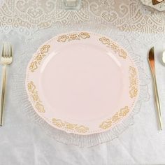 an empty plate on a white table cloth with silverware and utensils next to it