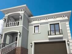 a two story house with an attached balcony and balconies on the second floor