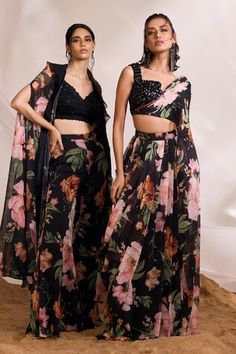 Black ruffled cape with all-over floral prints. Comes with coordinating printed flared pant and floral embellished blouse. - Aza Fashions Floral Print Chiffon Sets, Party Sets With Black Floral Print, Floral Print Sleeveless Party Set, Sleeveless Floral Print Party Set, Fitted Floral Print Georgette Sets, Black Floral Print Party Sets, Pre-draped Saree With Floral Print For Festivals, Diwali Floral Print Fitted Pre-draped Saree, Diwali Floral Print Pre-draped Saree