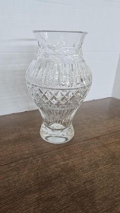 a clear glass vase sitting on top of a wooden table