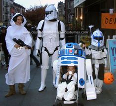 some people in costumes are walking down the street with a baby in a stroller