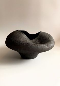 a black vase sitting on top of a white table