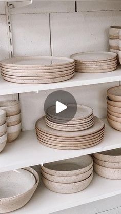 a shelf filled with plates and bowls on top of white shelves