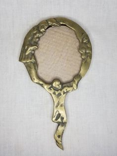 a gold colored mirror with an ornate design