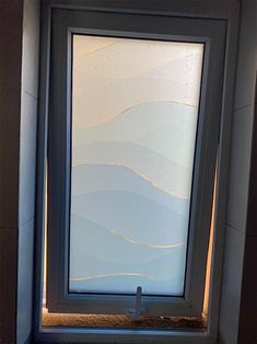 a bathroom with a toilet and a window in the corner, it appears to be made out of glass