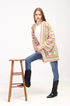 a woman is sitting on a stool and posing for the camera with her legs crossed