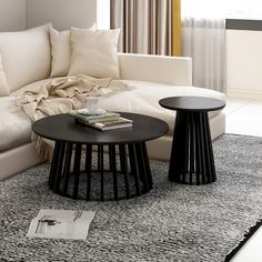 a living room with white couches and black tables in it's center area