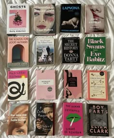 there are many different books on the bed together, including one that is pink and black