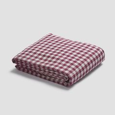 a red and white checkered blanket laying on top of a table