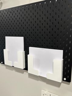 there are two white shelves on the wall next to each other with holes in them