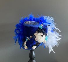 DreamsHead presents its novelty Beautiful medium mini blue thanksgiving hat It is covered with a dark blue velvet fabric and a plaid fabric on top, a blue satin ribbon and a blue stripe It is decorated with 3 mini velvet pumpkins (handmade by me), mini flowers An avalanche of feathers is added to the back of the hat Dimensions: 11.50cm high and 16.50cm wide at the edge it is a medium All my items are entirely handmade by me The color of the item may differ from your screen due to variance in com Blue Thanksgiving, Thanksgiving Hat, Dark Blue Velvet, Blue Velvet Fabric, Mini Flowers, Mini Top Hat, Halloween Hats, Velvet Pumpkins, Mini Top