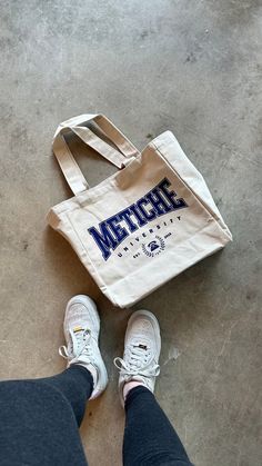 "You know we had to make a tote to complete the look! * 100% Cotton * Design reads: Metiche University * Screen printed with love by JZD in Brownsville, TX * Inside pocket * Measurements * Tote bag: 14\" x 14\" * Depth: 5.5\" * Handles: 11\"" Branded Tote Bags, Graphic Tote, For Her Gifts, Teacher Tshirts, Tote Bag Design, Cute Gifts, Inside Pocket, Gifts For Him, With Love