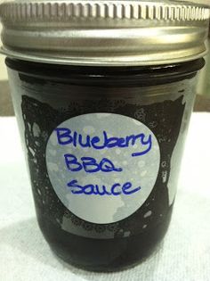 a jar of blueberry bbq sauce sitting on top of a white table cloth