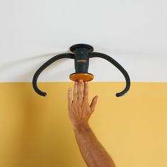 a hand is reaching up to the ceiling light