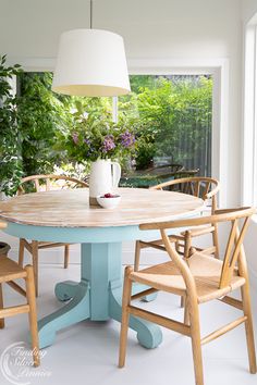 a dining room table with chairs around it and a vase on top of the table