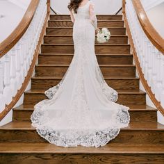 the bride is walking down the stairs in her wedding dress