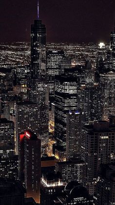 an aerial view of the city at night with skyscrapers lit up in red, white and blue