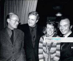 an old black and white photo of three men and a woman posing for the camera