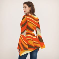 • Step into the past with our Groovy Bell Sleeve Top Women, a true representation of 70s style top.• Made from 100% polyester, this vintage-inspired top features large bell sleeves for that iconic 70s disco vibe.• With a wrap top bodice, high empire waistline, and loose-fitting lower bodice, it offers both style and comfort.• Stand out with the artistic multicolor orange, yellow, beige, and brown abstract stripe pattern print, perfect for adding a funky touch to any outfit.• Whether you're hitting the disco or embracing everyday bohemian style, pair it with bell-bottom pants and chunky heels or clogs for a head-turning look!Designed in California by Trendy Hip Buys. Handmade to order from overseas.100% Polyester● Fabric: 100% polyester● Regular fit● V-neck, Bell Sleeves● Fabric weight: 80g Women 70s, 1940s Fashion Dresses, Vintage Inspired Shoes, 1950s Fashion Dresses, Vintage Style Hat, Hippie Tops, 70s Disco, Yellow Beige, 1990s Fashion