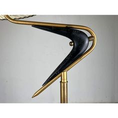 a black and gold metal lamp on a white wall