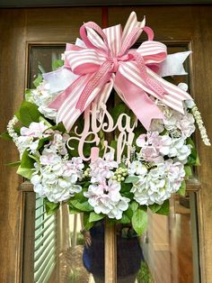 a pink and white wreath with the word dog mom hanging from it's front door