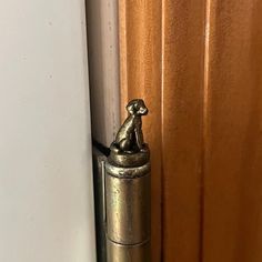 a cat figurine sitting on top of a door handle