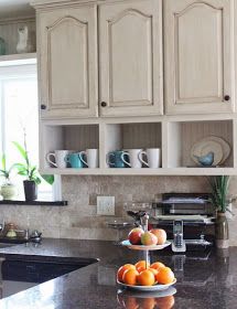 a bowl of fruit is sitting on the counter in this clean, well - organized kitchen