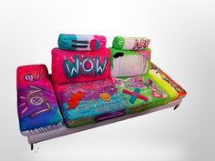 a couch made out of different types of items on top of each other, with the word wow painted on it