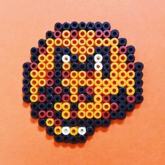 a piece of art made out of legos on an orange background with the image of a skull