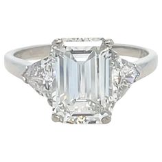 This absolutely stunning three stone diamond ring by Cartier features a 3.00 carat emerald cut diamond with F color and VS1 clarity, flanked by two trillion cut diamonds weighing approximately 1.00 carat total. Mounted in platinum and crafted with the highest of quality, this ring is sure to be cherished for a lifetime. Stamp: 10% IRID. PLAT. Car(obscured) 862531 Ring size: 7 3/4 Metal: Platinum Total Weight: 5.80 grams GIA, 2024, Report No. 6234216267, 3.00 carats, F color, VS1 clarity, No fluorescence Side Diamond Characteristics (insofar as the mounting permits): Color: F Clarity: VS1 and SI1 Gia Certified Trillion Cut Diamond Ring For Formal Events, Gia Certified Trillion Cut Diamond Ring For Formal Occasions, Cartier Platinum Diamond Ring With Prong Setting, Classic Formal Trillion Cut Emerald Ring, Classic Trillion Cut Emerald Ring For Formal Occasions, Trillion Cut White Gold Emerald Ring With Diamond, Cartier Diamond Wedding Rings Brilliant Cut, Cartier Diamond Ring With Brilliant Cut For Anniversary, Cartier Diamond Wedding Ring With Brilliant Cut