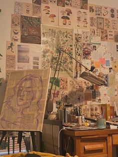 an artist's studio with lots of art work on the wall