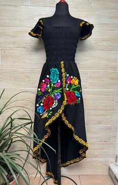 This beautiful dress is the perfect style to attend a Mexican party, with beautiful floral embroidery, has a spring at the waist to adjust the figure and a ducktail design. This dress is one size and fits S/M. Handcrafted machine embroidered dress. Each dress has unique embroidery so colors may vary. We ship anywhere in the word, from Tepic, Nayarit,  mx. Made by artisans from Oaxaca, Mx We recommend washing by hand with cold water, tender in the shade, to better preserve the original color. Fitted Dress With Embroidered Hem For Spring, Floral Embroidered Knee-length Summer Dresses, Embroidered Maxi Dress For Summer Party, Garden Party Midi Dress With Embroidered Hem, Summer Maxi Dress With Floral Embroidery, Summer Floral Embroidered Maxi Dress, Traditional Black Dress With Floral Print, Embroidered Multicolor Dresses For Garden Party, Traditional Knee-length Party Dresses