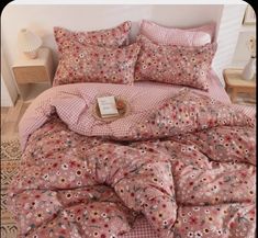 a bed covered in pink and white flowers on top of a checkered bedspread