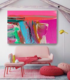 an abstract painting hangs on the wall above a pink couch and ottoman in a living room