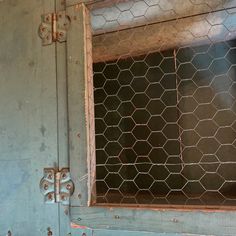 an old metal door with chicken wire on it