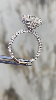 a diamond ring sitting on top of a pair of scissors