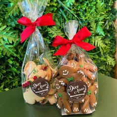 two bags filled with christmas cookies sitting on top of a table next to each other