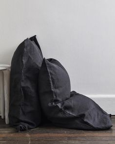 two black pillows sitting on top of a wooden floor