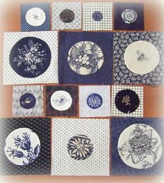 many plates are arranged in a grid pattern on the table top, with different designs