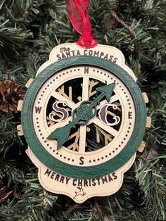 a christmas ornament hanging from a tree with the words santa compass on it