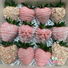 a box filled with lots of pink strawberries covered in white and pink frosting