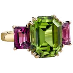 Wow! What an exciting color pairing of gemstone shapes and colors! This ring features a large, fine, grass-green peridot flanked by raspberry rhodolite garnets. The unusual cuts and fine colors of gemstones used make this an original version of the classic 3-stone ring. Handmade in 18k yellow and rose gold by our Master Jewelers in Los Angeles. Peridot, 12.77 x 10.14mm, 6.77 carats Rhodolite garnets, 7.00 x 5.00mm, 2.78 carat total Ring size 6.5 Complimentary sizing, as needed Rhodolite Garnet Ring, Diamond Rings With Price, Garnet And Diamond Ring, Contemporary Engagement Rings, Peridot Jewelry, Carved Ring, Ruby Diamond Rings, 3 Stone Rings, Garnet Ring