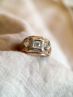 a diamond ring sitting on top of a white cloth