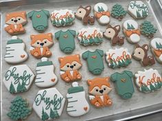 baby shower cookies are arranged on a cookie sheet in the shape of foxes and bears