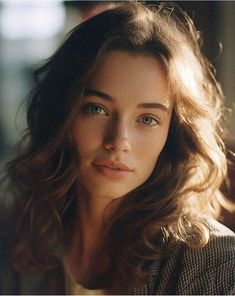 a close up of a woman with long hair and blue eyes looking at the camera