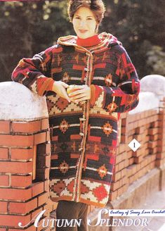 a woman standing on top of a brick wall next to a fire hydrant and wearing a sweater