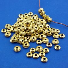 gold plated spacer beads on a blue background