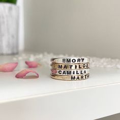 We are so excited to add our Little Id Personalized Stacking Rings to our ring collection. Perfect for stacking just like our original name ring but a little more delicate and feminine. Featuring an upper case letter font, you can comfortably stack up to 5 of these rings. Created to mix and match perfectly with the rest of our collection so you can create a ring stack that's just right for you. Keep your loves close, commemorate a special date or a short meaningful message, use symbols, it's totally up to you. Available options for personalization include heart, star, compass star, infinity symbol. Up to 12 characters max. Our Little ID Personalized Stacking Rings are available in sterling silver, 14kt gold, and rose gold fill. Each ring is hand-formed and stamped in our studio at the time Adjustable Stackable Initial Ring For Everyday, Adjustable Engraved Stackable Ring For Everyday, Everyday Adjustable Stackable Engraved Ring, Dainty Stacked Rings As A Gift, Minimalist Stacked Midi Rings As Gift, Minimalist Stacked Rings As Gift, Minimalist Stacked Rings Gift, Everyday Meaningful Hand Stamped Stackable Rings, Adjustable Stackable Initial Ring