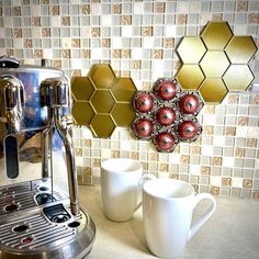 there is a coffee maker and two cups on the counter