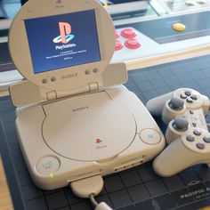 an old video game system with two controllers on top of it and the screen displaying the playstation logo